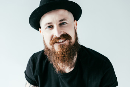 smiling handsome bearded man looking at camera isolated on whiteの写真素材