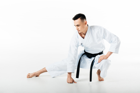 male karate fighter stretching isolated on whiteの写真素材