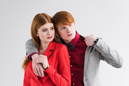 Young couple of fashion models with wristwatches isolated on greyの写真素材