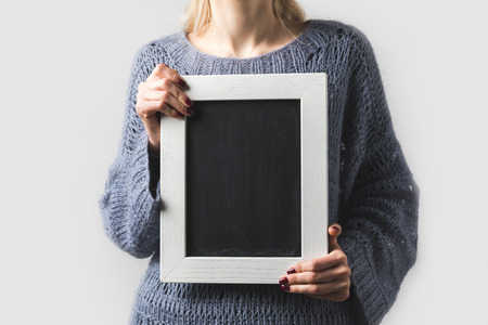 cropped image of woman holding empty black board isolated on whiteの写真素材