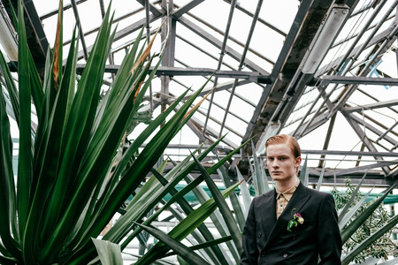 portrait of fashionable young red hair man in glasshouseの写真素材