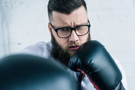 selective focus of concentrated businessman in boxing glovesの写真素材