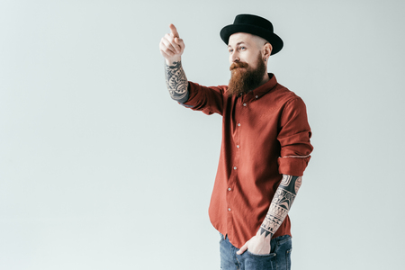 bearded handsome man pointing on something isolated on whiteの写真素材