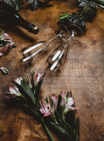 flowers, champagne bottle and glasses on wooden tableの写真素材