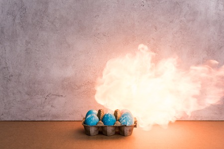Painted eggs on fire on grey background