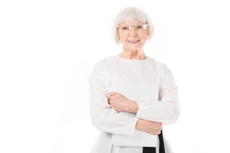 Senior stylish businesswoman in eyeglasses holding laptop isolated on whiteの写真素材