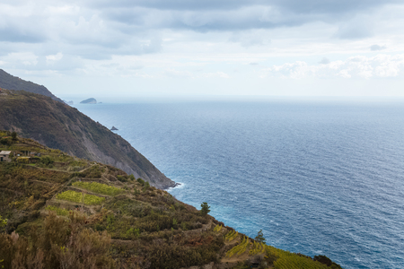 picturesque landscape with grassy hills and beautiful sea in Riomaggiore, Italyの写真素材