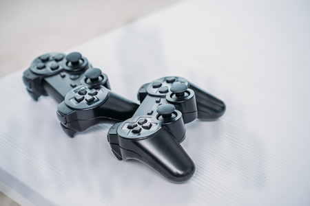 close up view of black gamepads for playing video game on grey tabletop