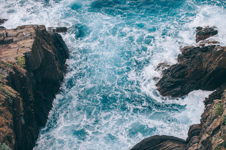 beautiful wavy sea and picturesque rocks in Riomaggiore, Italyの写真素材