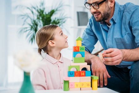 portrait of family building pyramid from colorful blocks at homeの写真素材