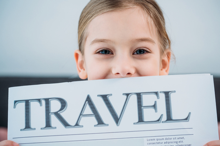 obscured view of cute child with travel newspaperの写真素材
