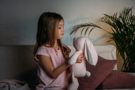 side view of cute kid with toy resting on sofaの写真素材