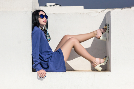 beautiful young woman in sunglasses sitting at white building in Egyptの写真素材