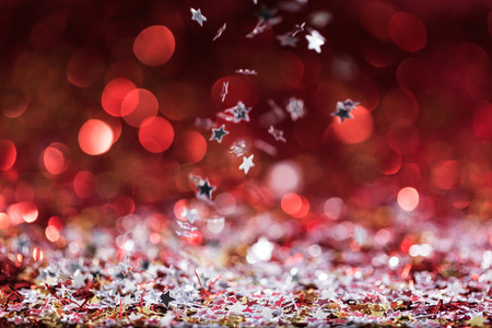 christmas background with falling red shiny confetti stars