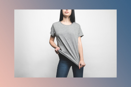 young woman in blank grey t-shirt on white with creative frameの写真素材
