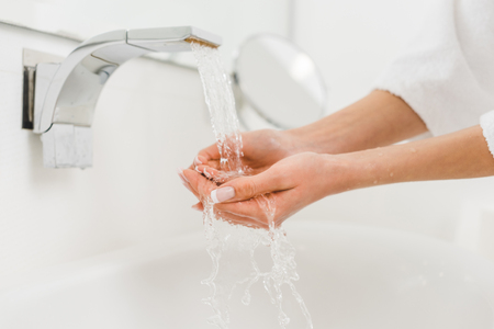 partial view of woman washing hands at home