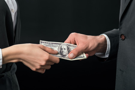 cropped view of businesspeople holding bribe, corruption concept, isolated on black