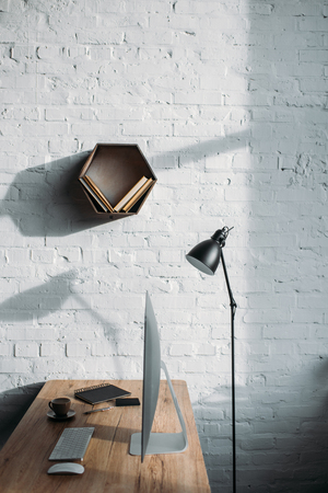 table lamp, computer and shelf on wall in officeの写真素材