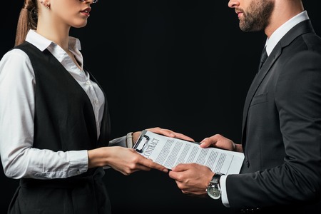 business colleagues holding contract, isolated on black