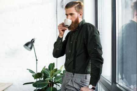 handsome businessman drinking coffee in officeの写真素材