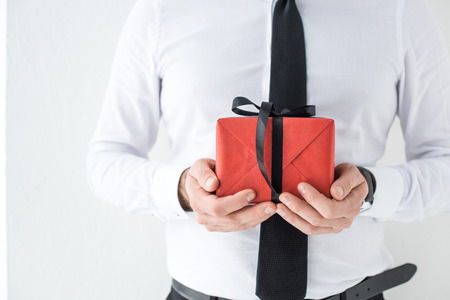 partial view of businessman with wrapped present in hands isolated on whiteの写真素材