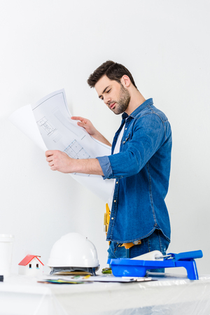 side view of man looking at blueprintの写真素材