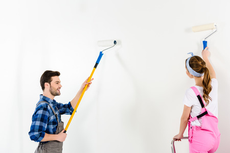 boyfriend and girlfriend painting wall with white paintの写真素材