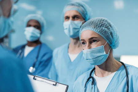 multicultural surgeons looking away in operating roomの写真素材