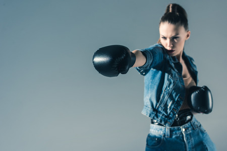 selective focus of boxing girl in denim clothes, isolated on greyの写真素材