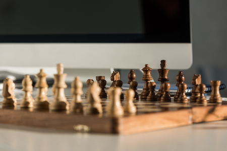 close-up shot of chess board at workplace near computerの写真素材