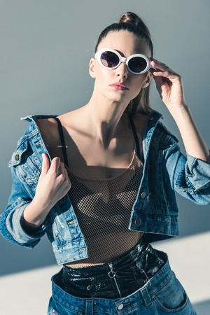 stylish model posing in denim clothes and sunglassesの写真素材