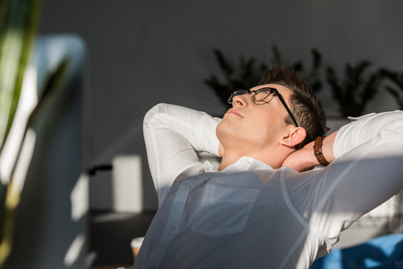 handsome young businessman relaxing at workplaceの写真素材