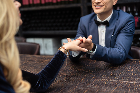 cropped shot of couple having date at restaurant and holding handsの写真素材