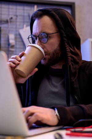 man drinking coffee and using laptopの写真素材