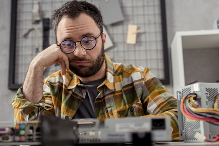 discouraged repairman looking at broken pcの写真素材