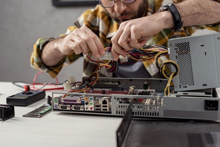 cropped image of man fixing computer part