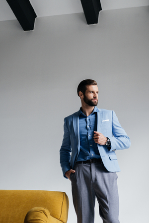 bearded stylish man posing in blue trendy suitの写真素材