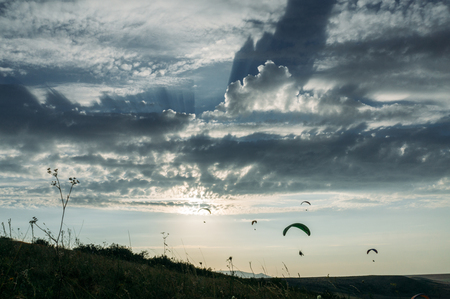 Parachutists gliding in blue sky over scenic landscape of Crimea, Ukraine, May 2013の写真素材