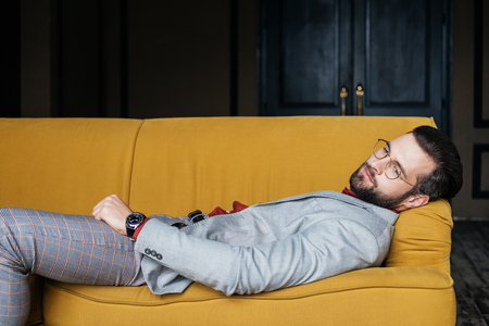 depressed elegant man resting and lying on couchの写真素材