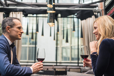 side view of adult couple drinking wine at restaurantの写真素材