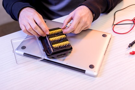 cropped image of hands and attachments to screwdriver over digital tablet