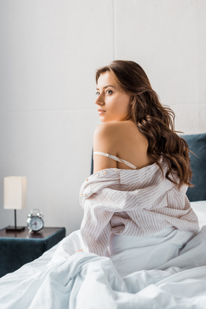 attractive tender woman sitting on bed in the morningの写真素材