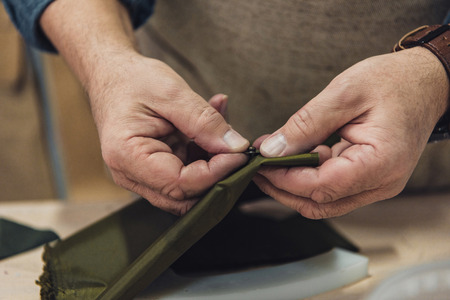 Cropped image of male handbag craftsman working at studioの写真素材