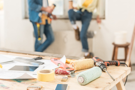 Close-up view of tools and digital devices on table during house repairmentの写真素材