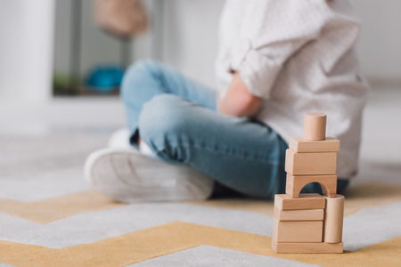 Cropped shot of child sitting on floor with wooden blocksの写真素材