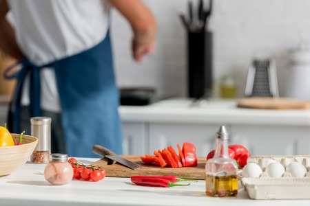 Close up view of chopped pepper on cutting board with cooker at backgroundの写真素材