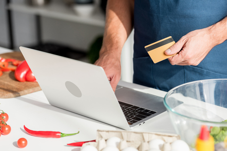 Partial view of man making shopping online on laptopの写真素材