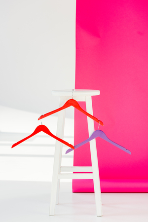 Multicolored painted hangers with white wooden chairの写真素材