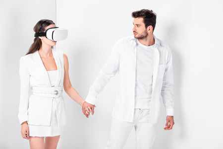 Adult man walking with woman in virtual reality headsetの写真素材