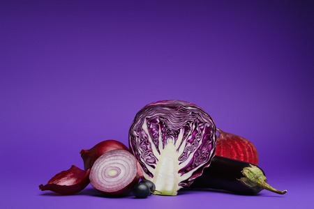 sliced cabbage, onions, grapes, beetroot and eggplant on purpleの写真素材
